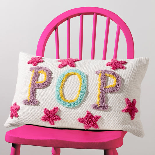 Decorative pillow with 'POP' and star patterns on a pink chair